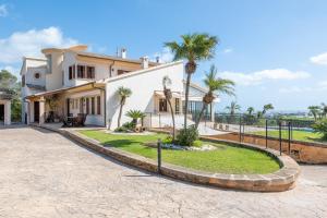 a house with palm trees and a driveway at Villas2meet Na Penyal 7 in Cala Millor