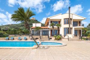 a villa with a swimming pool and a house at Villas2meet Na Penyal 7 in Cala Millor