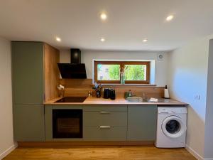 a kitchen with a sink and a washing machine at Entre Terre et Vignes - Studio climatisé in Marlenheim