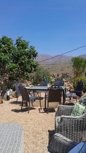 a group of tables and chairs with a view of mountains at Sunrise Hill Guest House in Los Gallardos