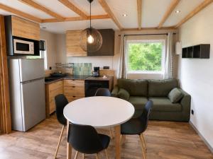 a kitchen and living room with a table and a couch at Villages de Chalets et camping La Pierre de l'Aigle in La Bréole
