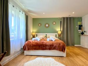 a bedroom with a bed and a green wall at Entre Terre et Vignes - Studio climatisé in Marlenheim