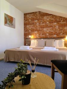 a hotel room with two beds and a brick wall at Family Hotel Brilliance in Varna City