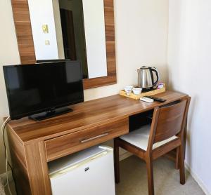a television sitting on a wooden desk in a room at Family Hotel Brilliance in Varna City