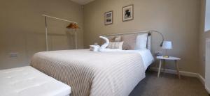 a bedroom with a white bed with a stuffed animal on it at Stoney Lane Cottage in Wakefield