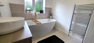 a bathroom with a large white tub and a sink at Stoney Lane Cottage in Wakefield