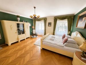 a bedroom with a large bed and green walls at Astronomical Clock Apartment in Prague