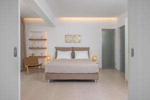 a bedroom with a bed and a chair at Aegean View Estate - Villa in Faliraki +19 photos