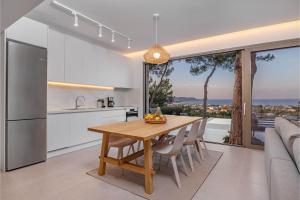 a kitchen and dining room with a wooden table with chairs at Aegean View Estate - Villa in Faliraki