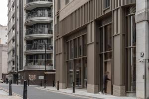 a man walking down a street in front of a building at Buckle Street Studios by Locke, Aldgate in London