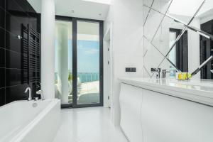 a white bathroom with two sinks and a large window at Dune Resort Mielno - B in Mielno +221 photos