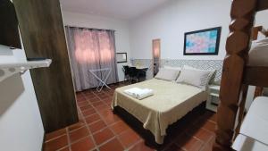 a small bedroom with a bed and a table at Lar de Nanci e Beto in Arraial do Cabo