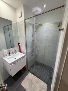a bathroom with a glass shower and a sink at Spacious Studio Apt Airport Residential in Accra +10 photos
