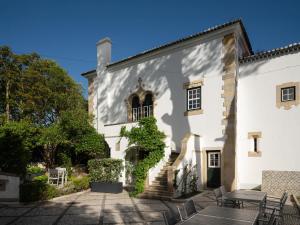 a white building with stairs and tables and chairs at Villa Vasco da Gama in Cascais