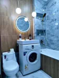 a bathroom with a washing machine and a toilet at Taraz 2 in Taraz