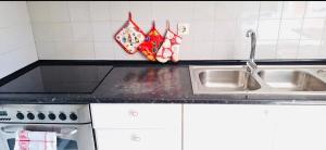 a kitchen counter with a sink and a stove at Cantinho de Matosinhos in Senhora da Hora