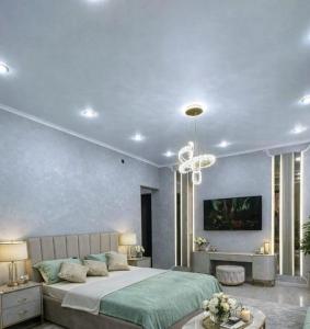 a bedroom with a large bed and a chandelier at Taraz 2 in Taraz