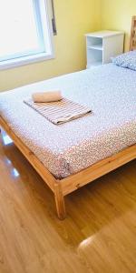 a bed with a wooden frame in a room at Cantinho de Matosinhos in Senhora da Hora