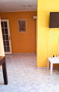 a room with a yellow wall and a tv at Cantinho de Matosinhos in Senhora da Hora +5 photos