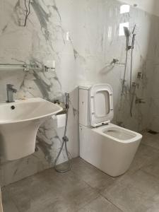 a bathroom with a white toilet and a sink at Jesuit Residence in Galle