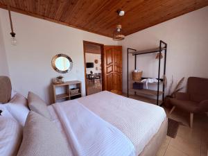 a bedroom with a large white bed and a chair at Dream house Villa in Alyki