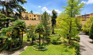 a garden with palm trees in front of a building at San Felice Central Room in Bologna