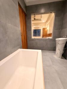 a white bath tub in a bathroom with a mirror at Rishaan Regency in Silchar