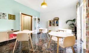 a dining room with white tables and white chairs at San Felice Central Room in Bologna