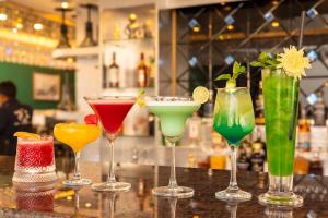 a group of different colored cocktails sitting on a bar at Swoorna Kara in Kathmandu