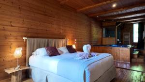 a bedroom with a bed in a log cabin at Hotel La Font Vineuse & Spa in Saint-Pierre-dʼArgençon