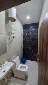 a bathroom with a white toilet and a sink at Hotel dream house 2 in Murādnagar
