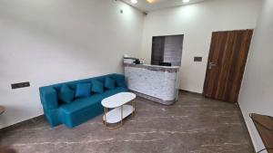 a living room with a blue couch and a stool at Hotel dream house 2 in Murādnagar