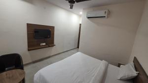 a bedroom with a bed and a tv in it at Hotel dream house 2 in Murādnagar