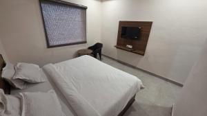 a bedroom with a bed and a flat screen tv at Hotel dream house 2 in Murādnagar +1 photo
