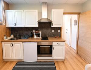 a kitchen with white cabinets and a sink at Solea Apartment in Woditz
