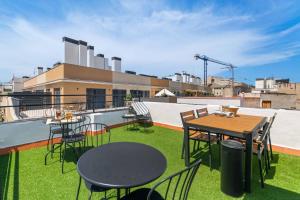 a patio with tables and chairs on a roof at Rambla de Mar Apartments by Blossom Hotels in Barcelona