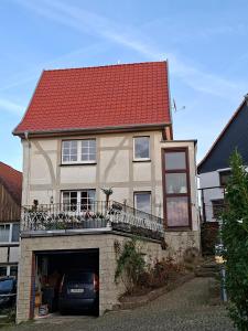 a house with a red roof with a garage at Fewo Froschkönig in Schieder-Schwalenberg