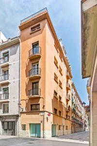 an orange building with balconies on a street at Rambla de Mar Apartments by Blossom Hotels in Barcelona