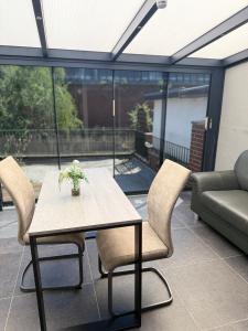 a table and chairs on a patio with a couch at Beautiful Apartment in Mönchengladbach mit Wintergarten in Mönchengladbach