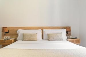 a large bed with white sheets and pillows at Rambla de Mar Apartments by Blossom Hotels in Barcelona