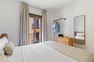 a bedroom with a large white bed and a mirror at Rambla de Mar Apartments by Blossom Hotels in Barcelona +40 photos