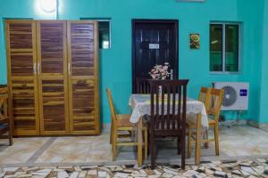 a dining room with a table and chairs and a blue wall at Résidence Royale Emma in Abidjan +5 photos