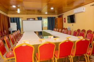 a conference room with a long table and red chairs at Résidence Royale Emma in Abidjan