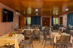 a dining room with white tables and chairs at Résidence Royale Emma in Abidjan