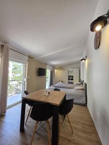 a bedroom with a bed and a wooden table and chairs at Apartments Sunce in Podaca