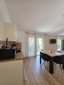 a kitchen with a table and a dining room at Apartments Sunce in Podaca