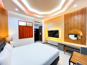 a bedroom with a white bed and a tv at เซฟเฮ้าส์ รีสอร์ท in Pattani +26 photos