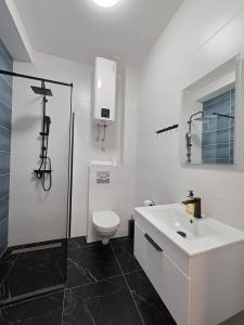 a white bathroom with a toilet and a sink at Apartments Sunce in Podaca +46 photos