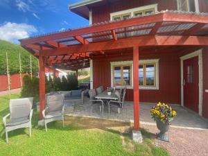 a pergola on a patio with a table and chairs at Nära centrum med sjöutsikt -Korsgården in Rättvik