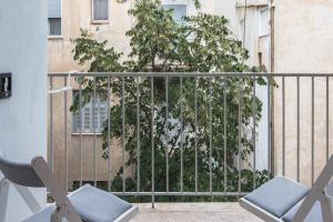 two chairs sitting on a balcony with a tree at Syntagma Gem 2 in Athens